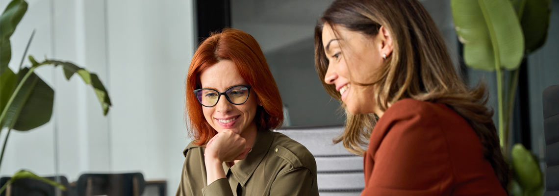two happy women talking in the office