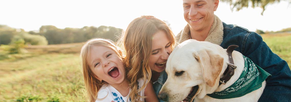 happy family playing with their pet dog