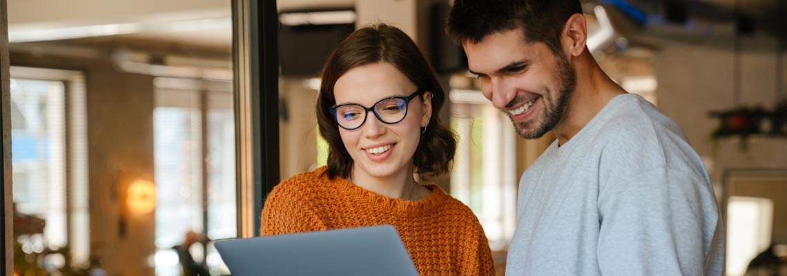 colleagues discussing project while working with laptop in office