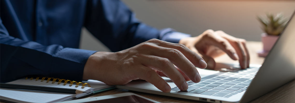 A man is typing on a laptop