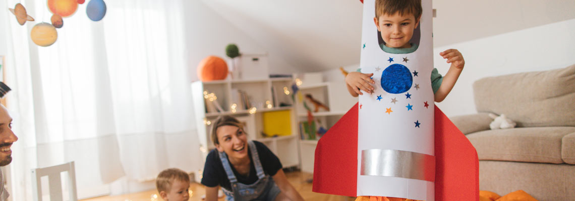 Young boy in a rocket costume playing with his family