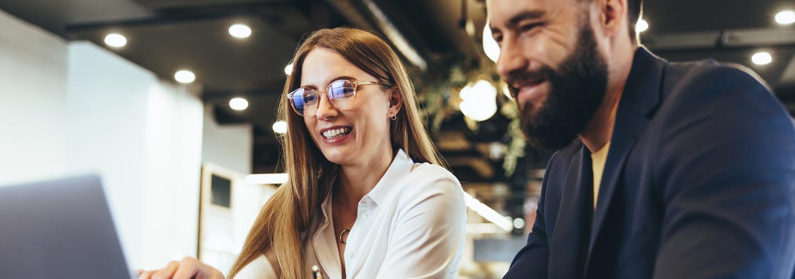 Cheerful businesspeople using a laptop in an office