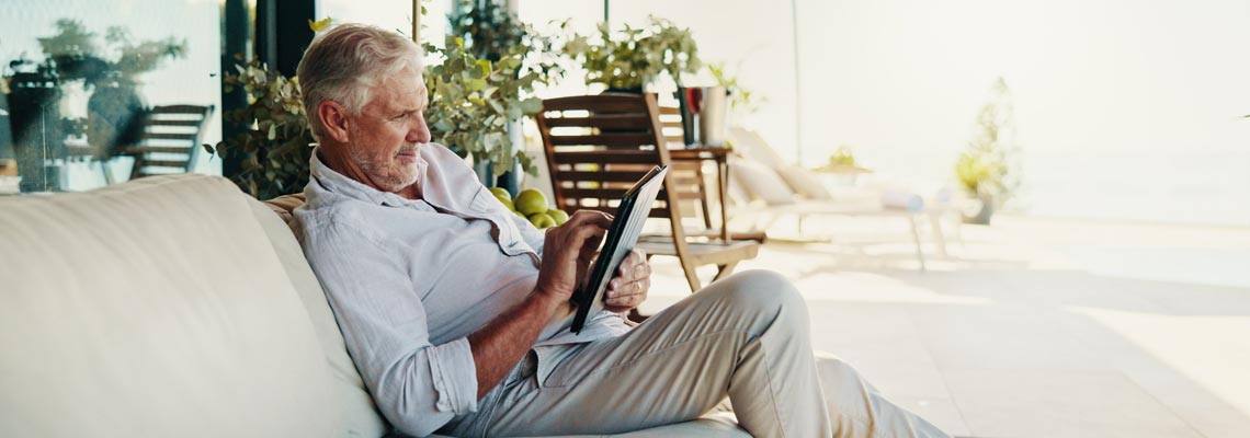 senior man with tablet sitting on the sofa
