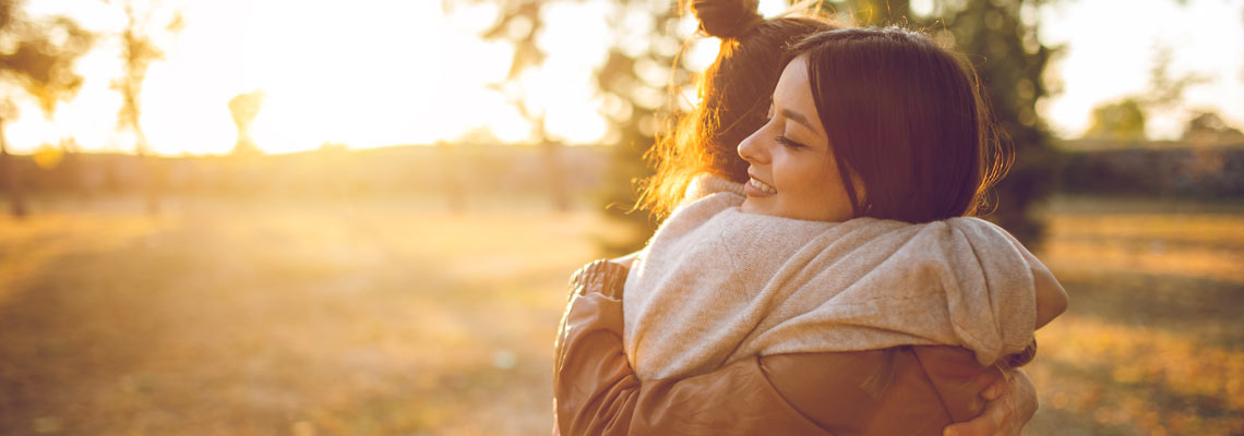 Mother and daughter hugging outdoors