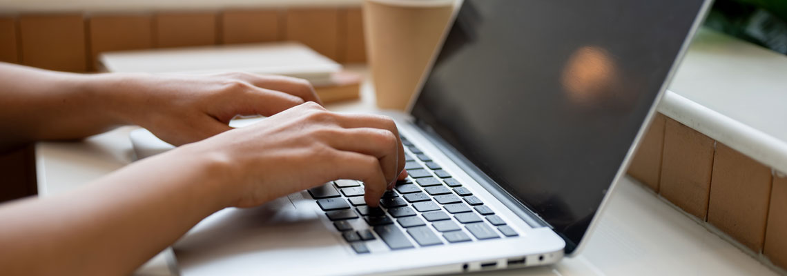 person using typing on a laptop