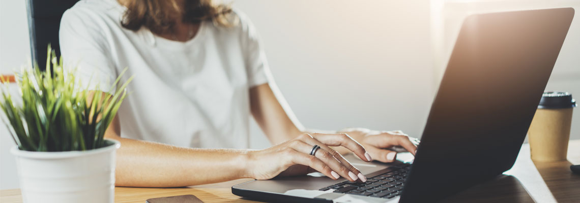 young female using laptop while working at her office