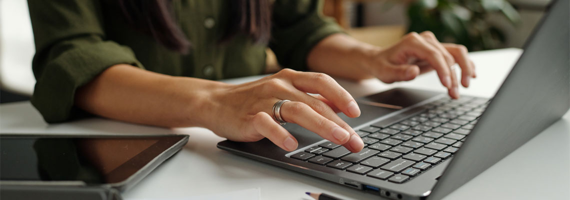 Hands typing on a laptop