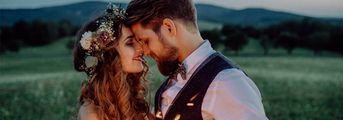 bride and groom with sparklers on a meadow