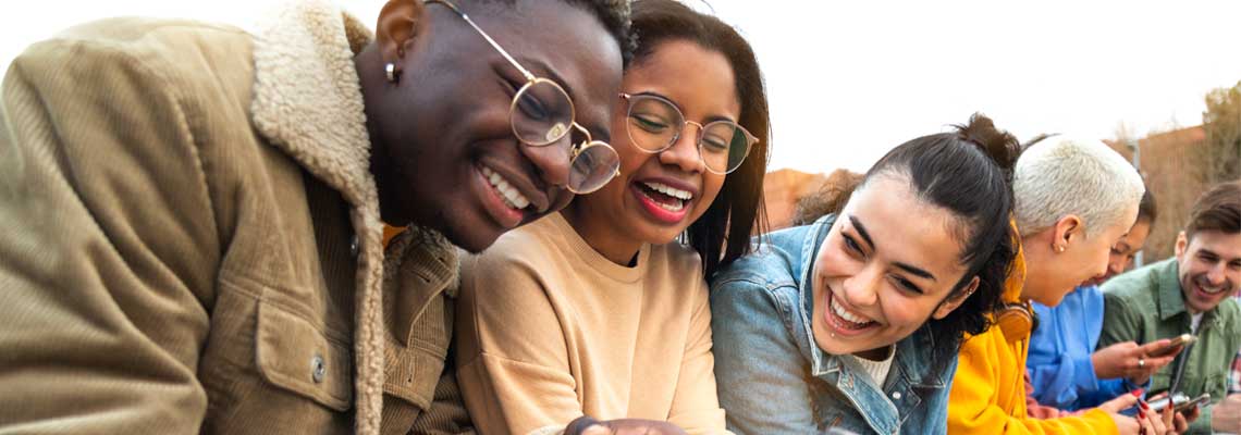 multiracial college students having fun using mobile phone