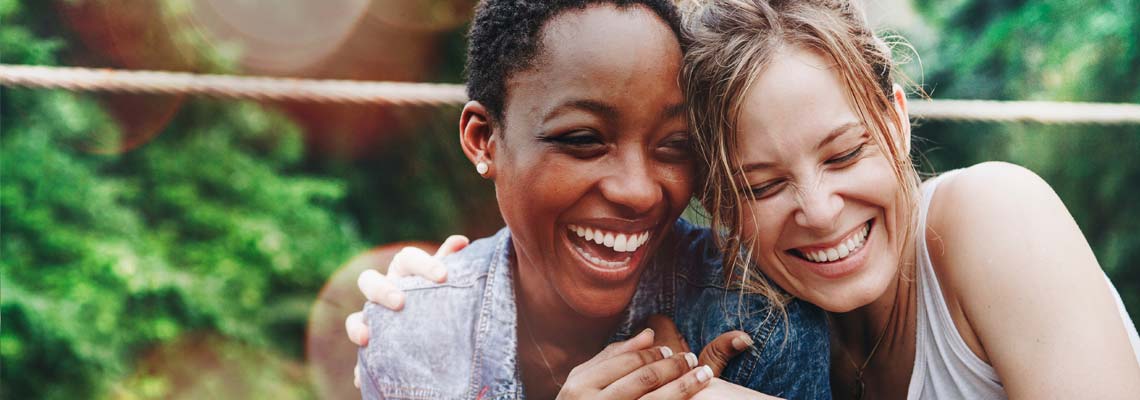 two happy women hugging and laughing